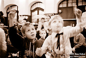 Two Jewish boys raising their hands, eager to answer a Judaica quiz question at a Chanukah (Hanukah) children's party held in Prague, Czech Republic Jewish Community's eating hall.