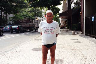 Older brazilian man in white T-shirt with the inscription "Quem é Flamengo, Deus ajuda. Quem não é - Deus ... Perdoa" in Rio de Janeiro, Brazil