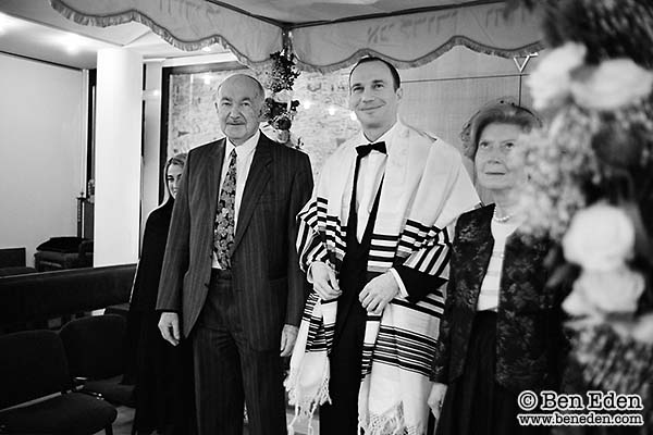 Groom standing under the Chuppah with his parents Groom standing under the Chuppah with his parents